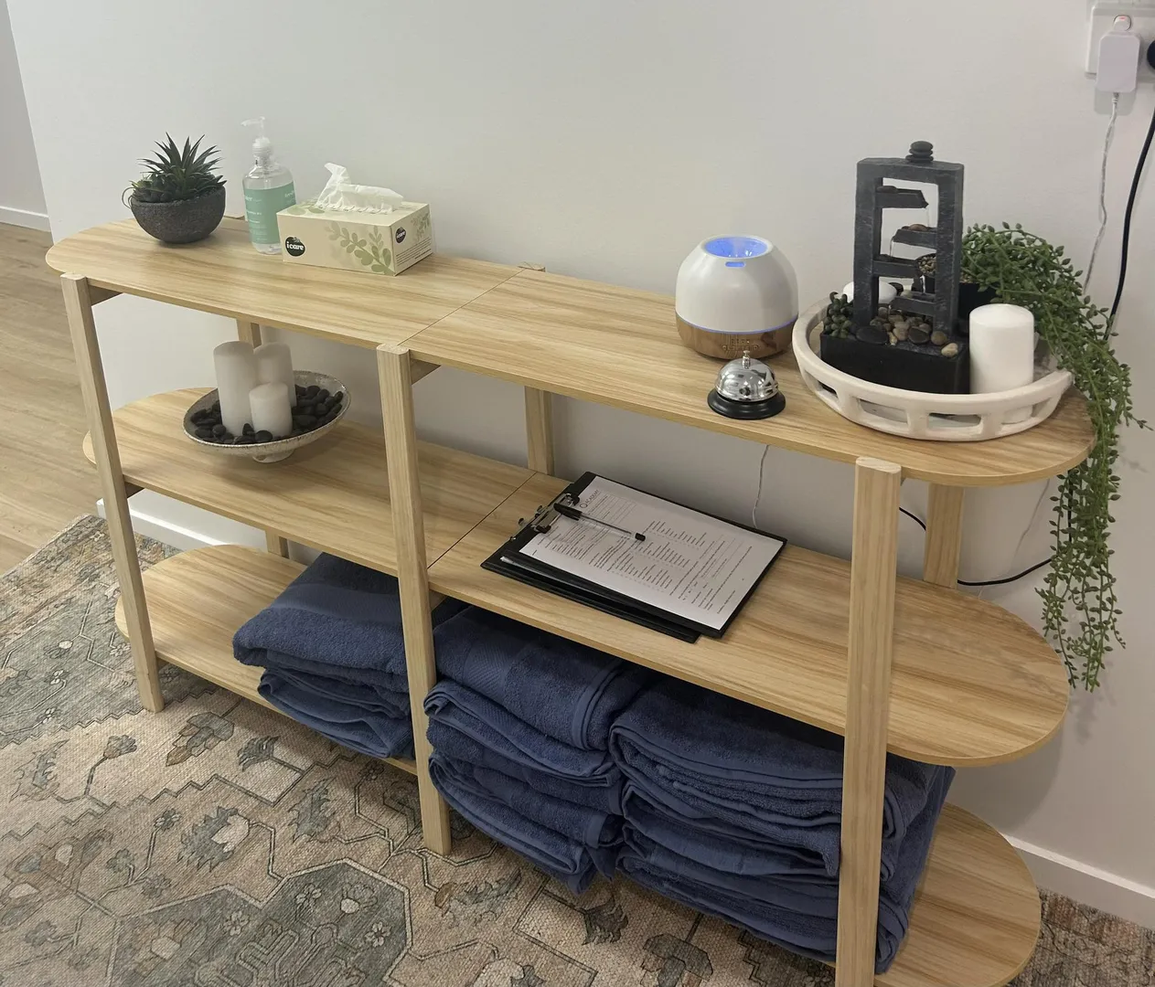 Wooden shelf with towels, decorations, and spa items.
