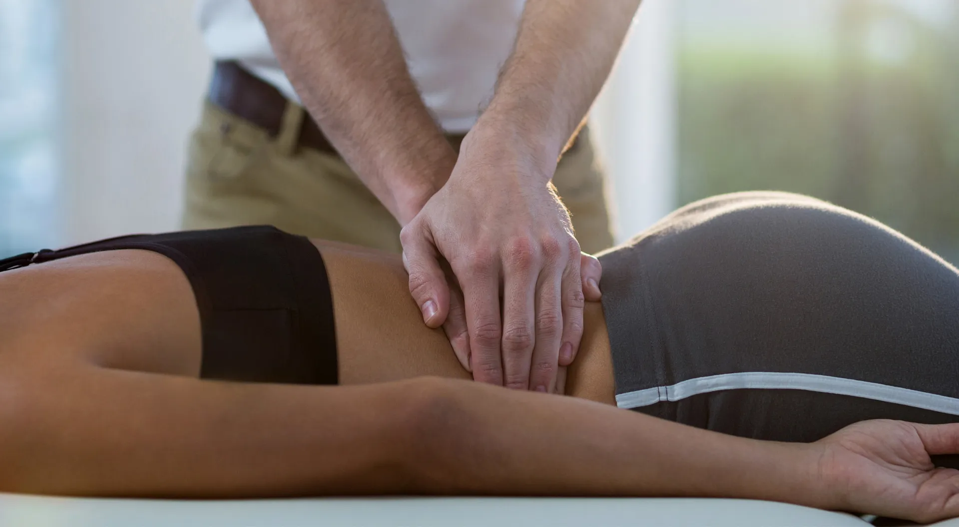 Chiropractor performing lower back adjustment therapy session